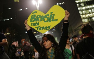 A woman holds up a heart-shaped sign that reads in Portuguese "One Brazil for all," on Paulista Avenue where crowds gathered to celebrate the reversal of a fare hike on public transportation, in Sao Paulo, Brazil, Thursday, June 20, 2013. After a week of mass protests, Brazilians won the world's attention and a pull-back on the subway and bus fare hikes that had first ignited their rage. Protesters gathered for a new wave of massive demonstrations in Brazil on Thursday evening, extending the protests that have sent hundreds of thousands of people into the streets since last week to denounce poor public services and government corruption. (AP Photo/Nelson Antoine)